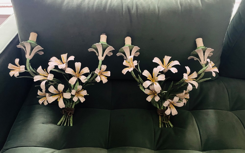 A pair of French painted metal wall sconces designed as floral bouquets with white petals and green stems.