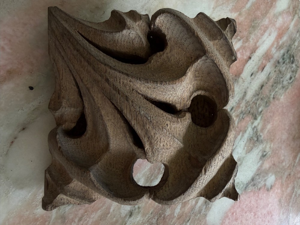 A square hand-carved oak architectural ceiling boss featuring deeply carved pierced leaf motifs in medium brown wood.
