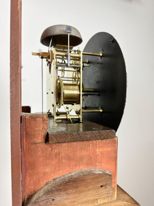 fig 3. A Georgian tall mahogany longcase clock featuring an arched hood, a circular dial with Roman numerals, and brass fluted quarter columns.