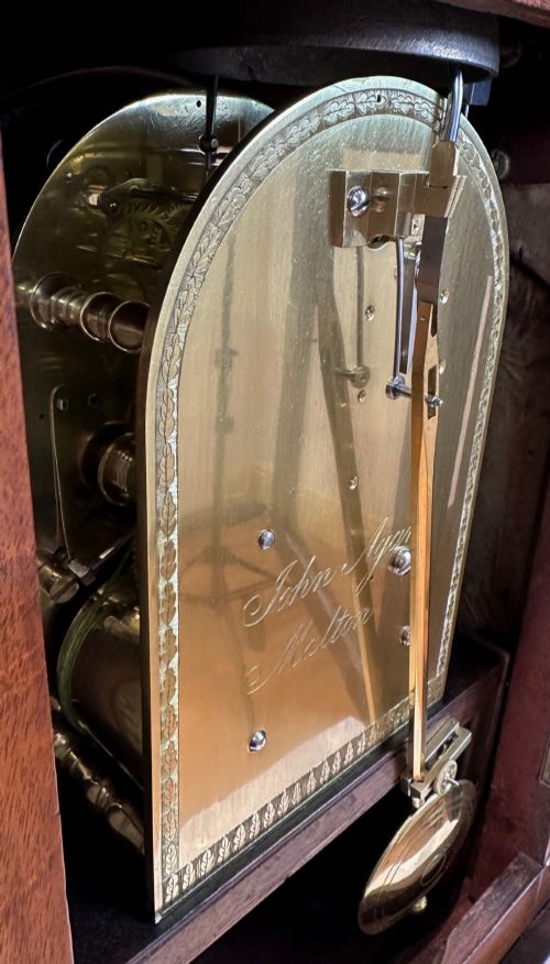 fig 5. A Georgian mahogany bracket clock featuring a brass pineapple finial, brass side handles, a white dial with Roman numerals, and a lower strike-silent mechanism.