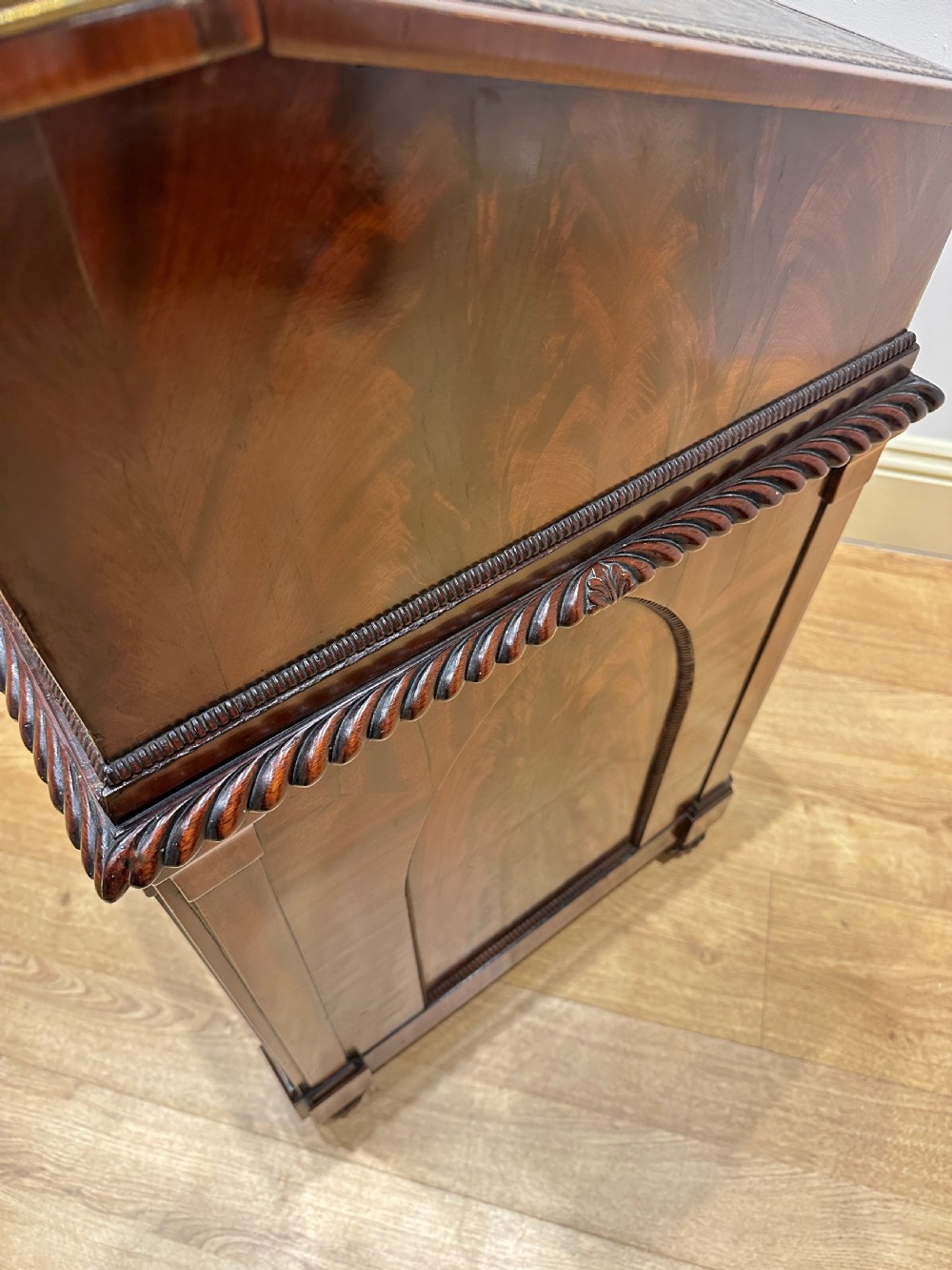 An antique Georgian mahogany Davenport desk featuring a sloped leather writing surface, decorative brass gallery, and side-mounted drawers. View VII