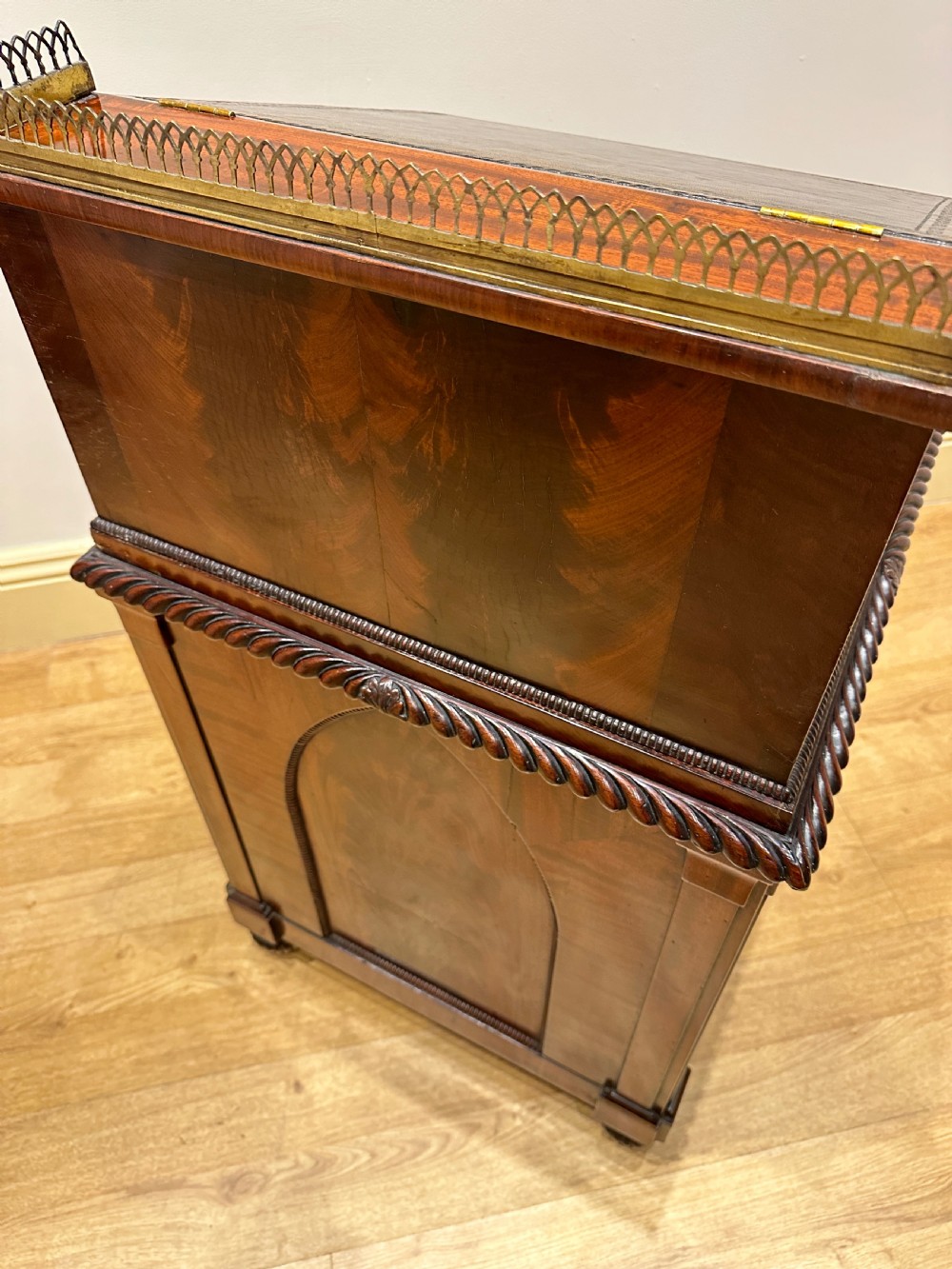 An antique Georgian mahogany Davenport desk featuring a sloped leather writing surface, decorative brass gallery, and side-mounted drawers. View VIII