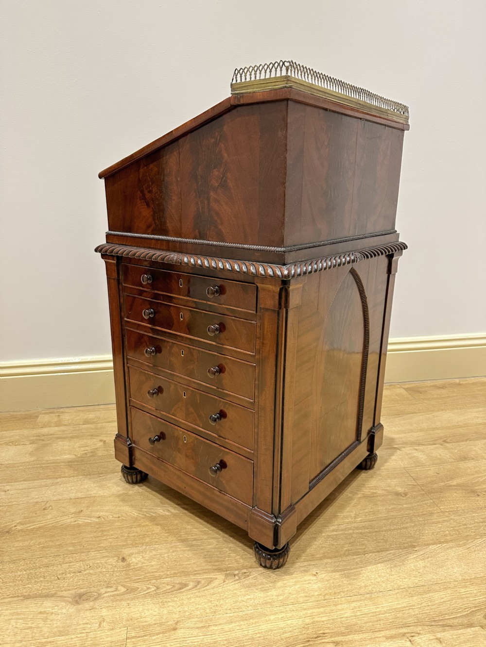 An antique Georgian mahogany Davenport desk featuring a sloped leather writing surface, decorative brass gallery, and side-mounted drawers. View XV