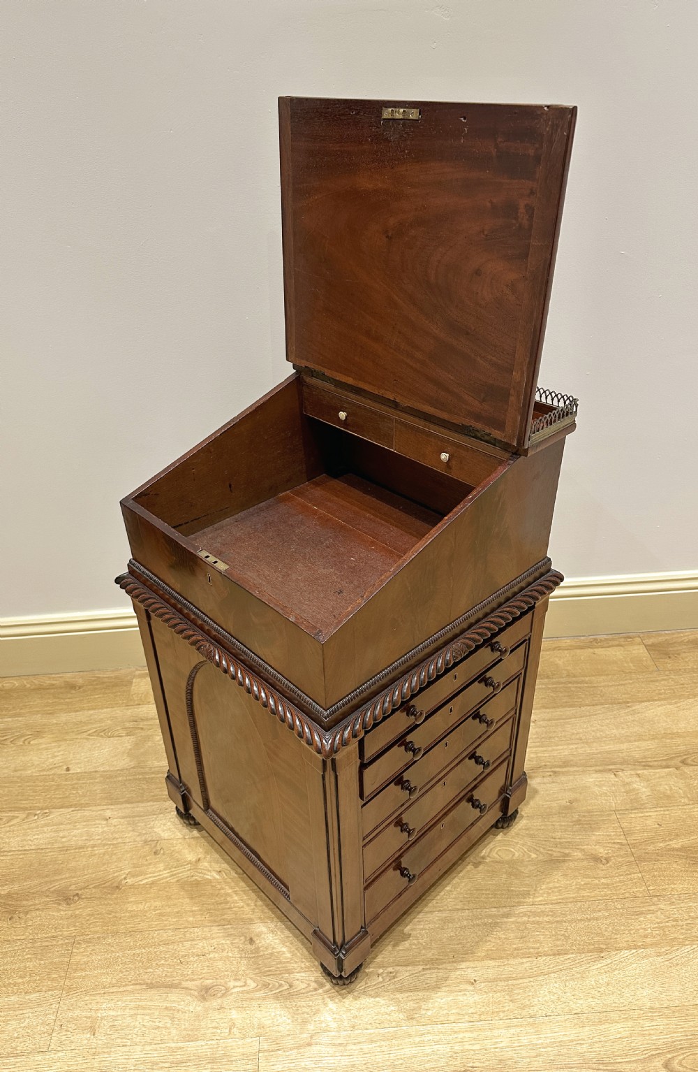 An antique Georgian mahogany Davenport desk featuring a sloped leather writing surface, decorative brass gallery, and side-mounted drawers. View XVIII