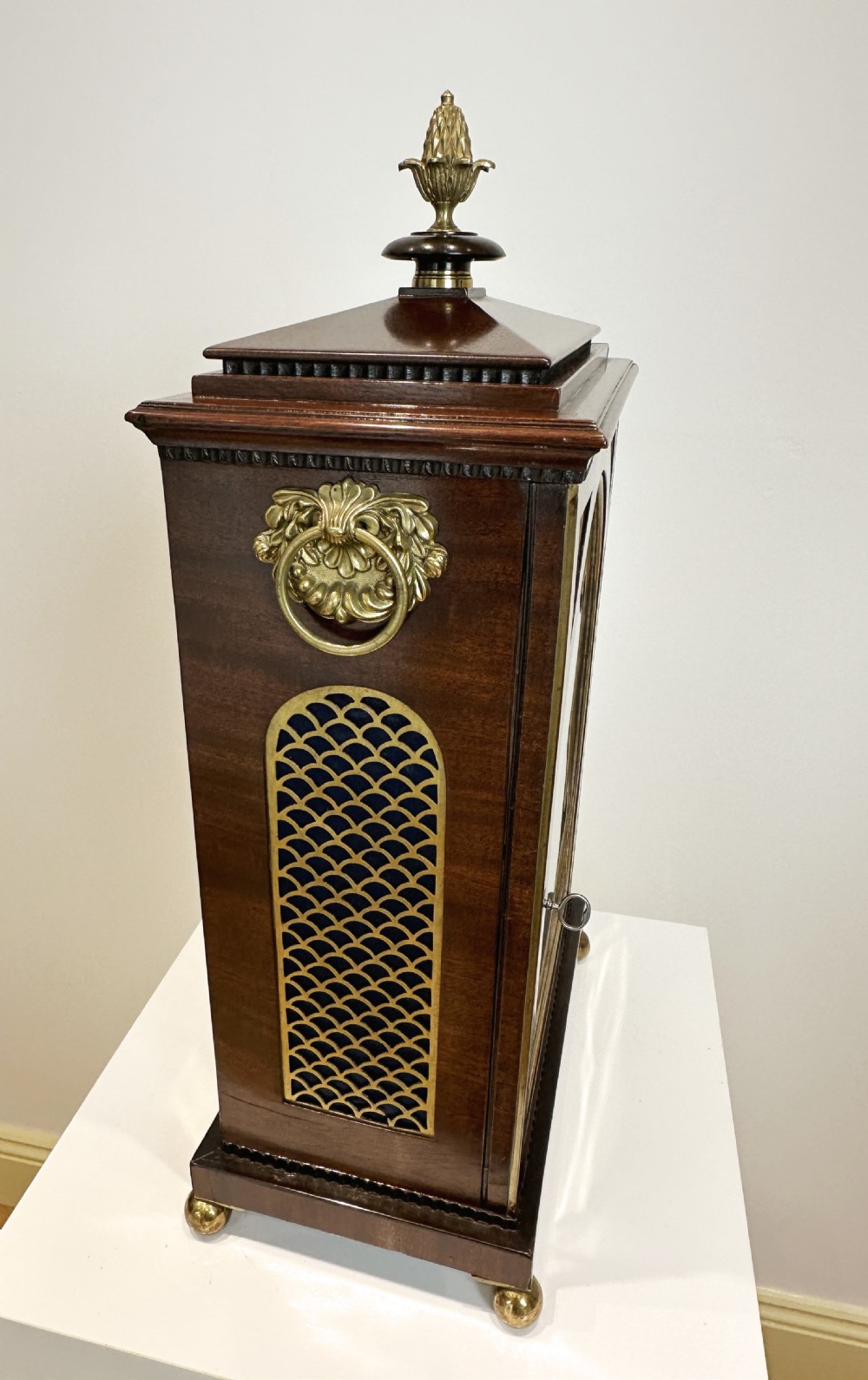 A Georgian mahogany bracket clock featuring a top brass pineapple finial, brass side handles, brass feet, and a arched dial signed John Agar Malton with a strike silent indicator. View XVII