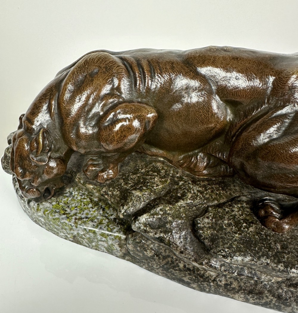 A patinated dark brown bronze sculpture depicting a crouching panther drinking water from a speckled grey stone base. View XI