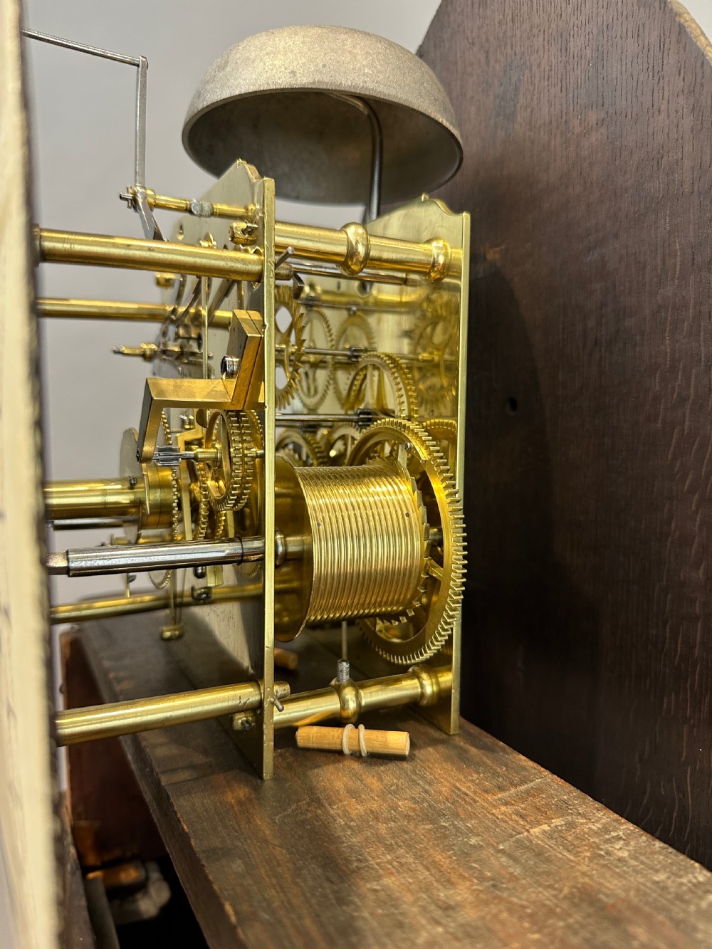 A Regency flame mahogany longcase clock featuring a pointed arch hood, white circular dial signed by Thomas Wightman of London, and brass column details. View VII