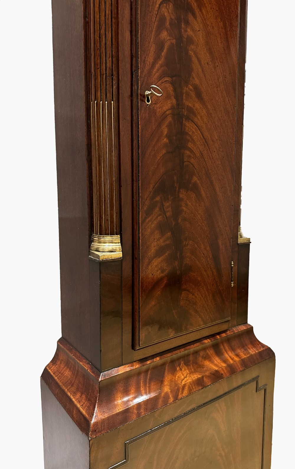 A Regency flame mahogany longcase clock featuring a pointed arch hood, white circular dial signed by Thomas Wightman of London, and brass column details. View XII