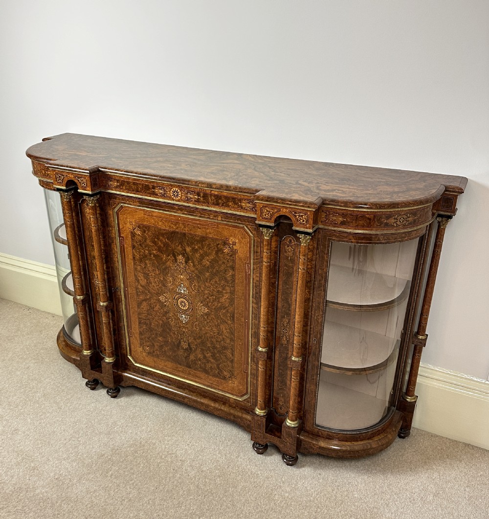 A Victorian burr walnut credenza sideboard featuring intricate marquetry inlay, a central panelled cupboard door, two curved glass display doors, and gilt brass mounts. View II