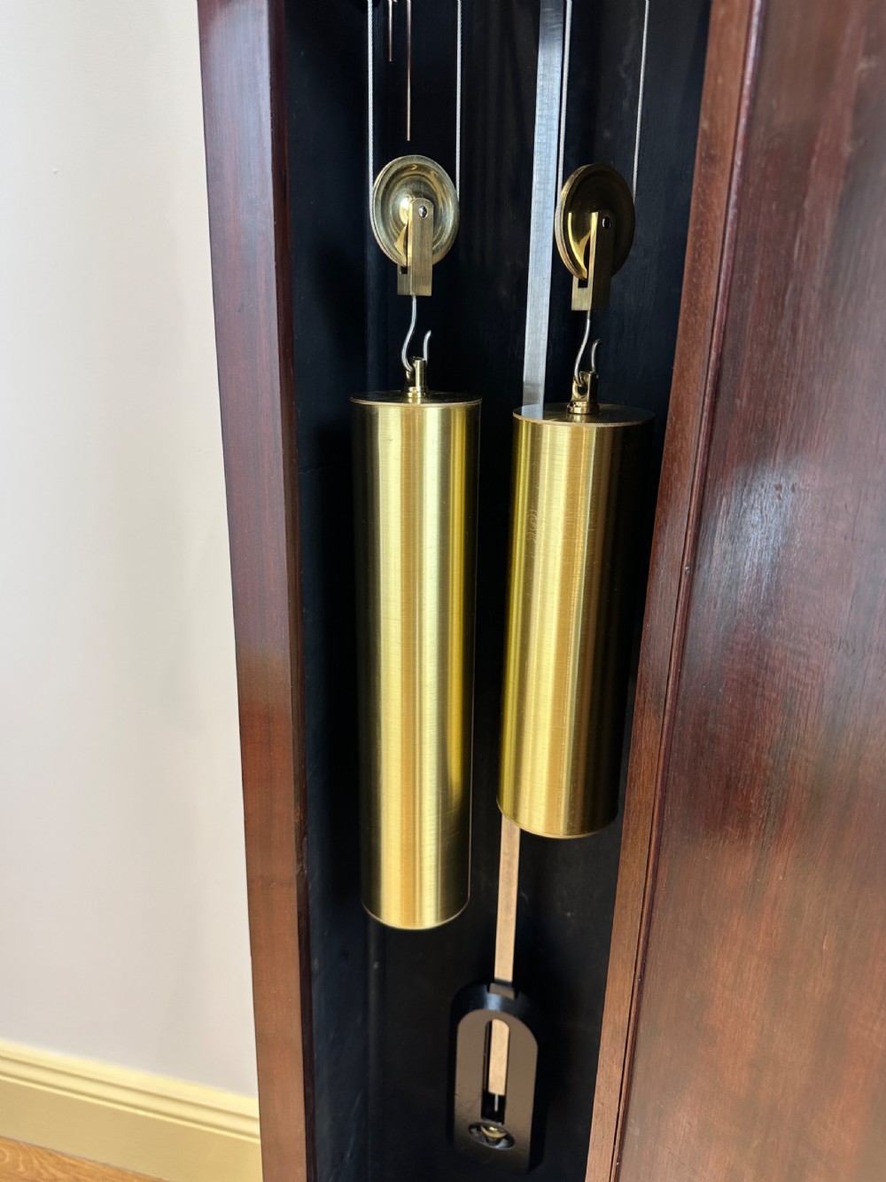 A tall mahogany grandmother clock featuring a brass and silvered dial with Roman numerals, geometric carved mouldings, and bracket feet. View XII