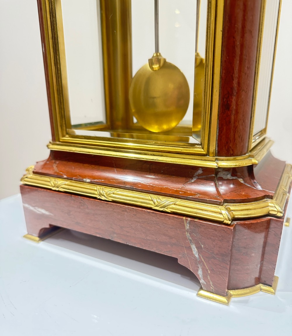 A French four-glass mantel clock featuring a rouge marble top and base, gilt ormolu mounts, a ribbon bow crest, and an enamel dial signed Le Roy & Fils. View VI