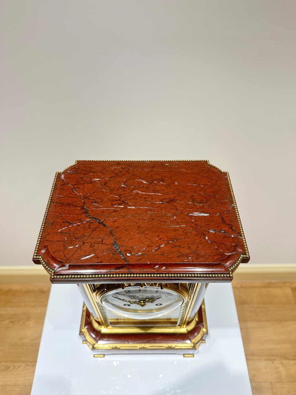 A French four-glass mantel clock featuring a rouge marble top and base, gilt ormolu mounts, a ribbon bow crest, and an enamel dial signed Le Roy & Fils. View XI