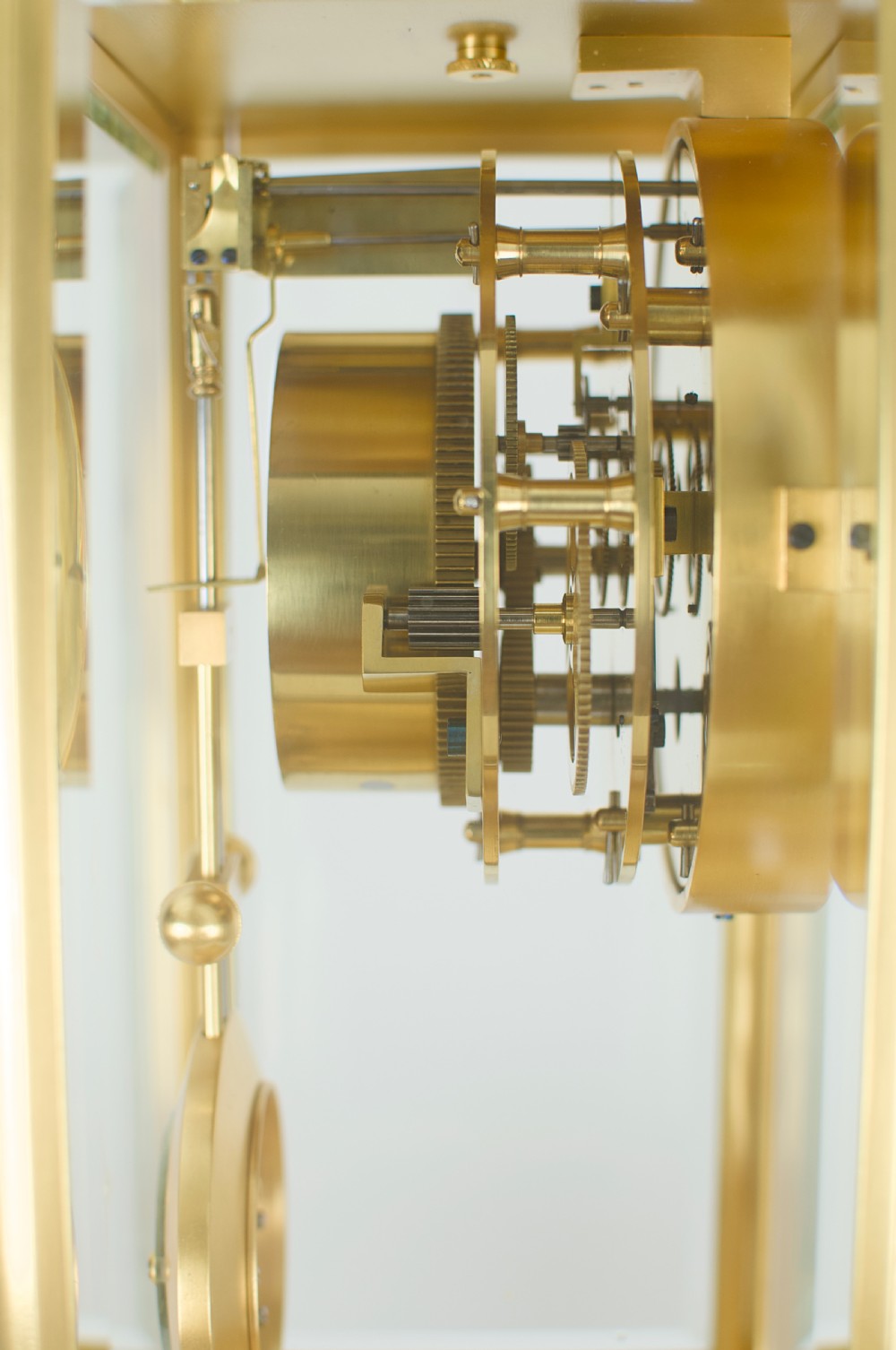 A nineteenth-century French four-glass mantel clock with a gilt brass case, white enamel dial with Roman numerals, exposed Brocot escapement, and visible pendulum. View IX