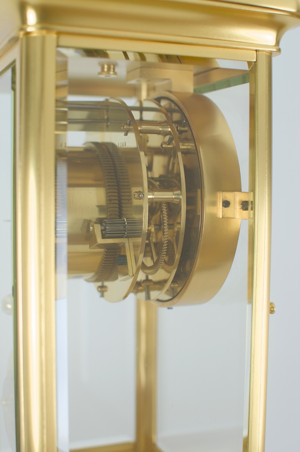 A nineteenth-century French four-glass mantel clock with a gilt brass case, white enamel dial with Roman numerals, exposed Brocot escapement, and visible pendulum. View X