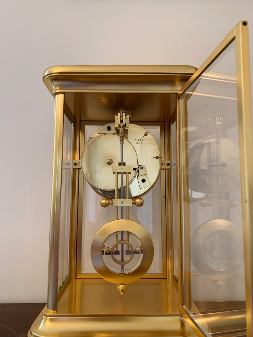 A nineteenth-century French four-glass mantel clock with a gilt brass case, white enamel dial with Roman numerals, exposed Brocot escapement, and visible pendulum. View XIII
