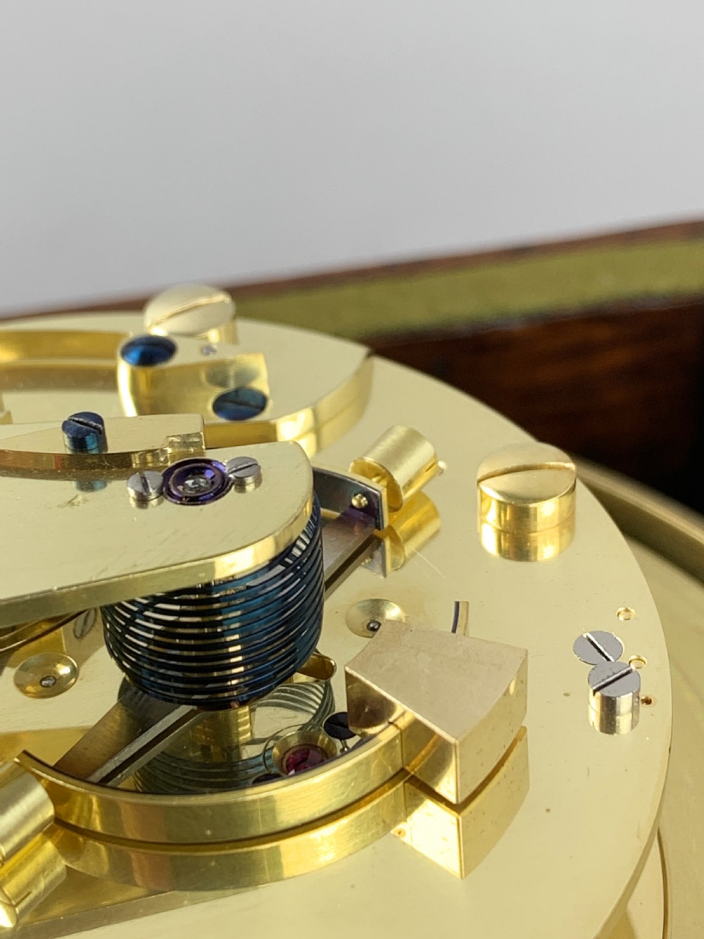 An antique 19th-century brass-bound wooden box opening to reveal a gimballed marine chronometer clock with a silvered dial and Roman numerals. View IV
