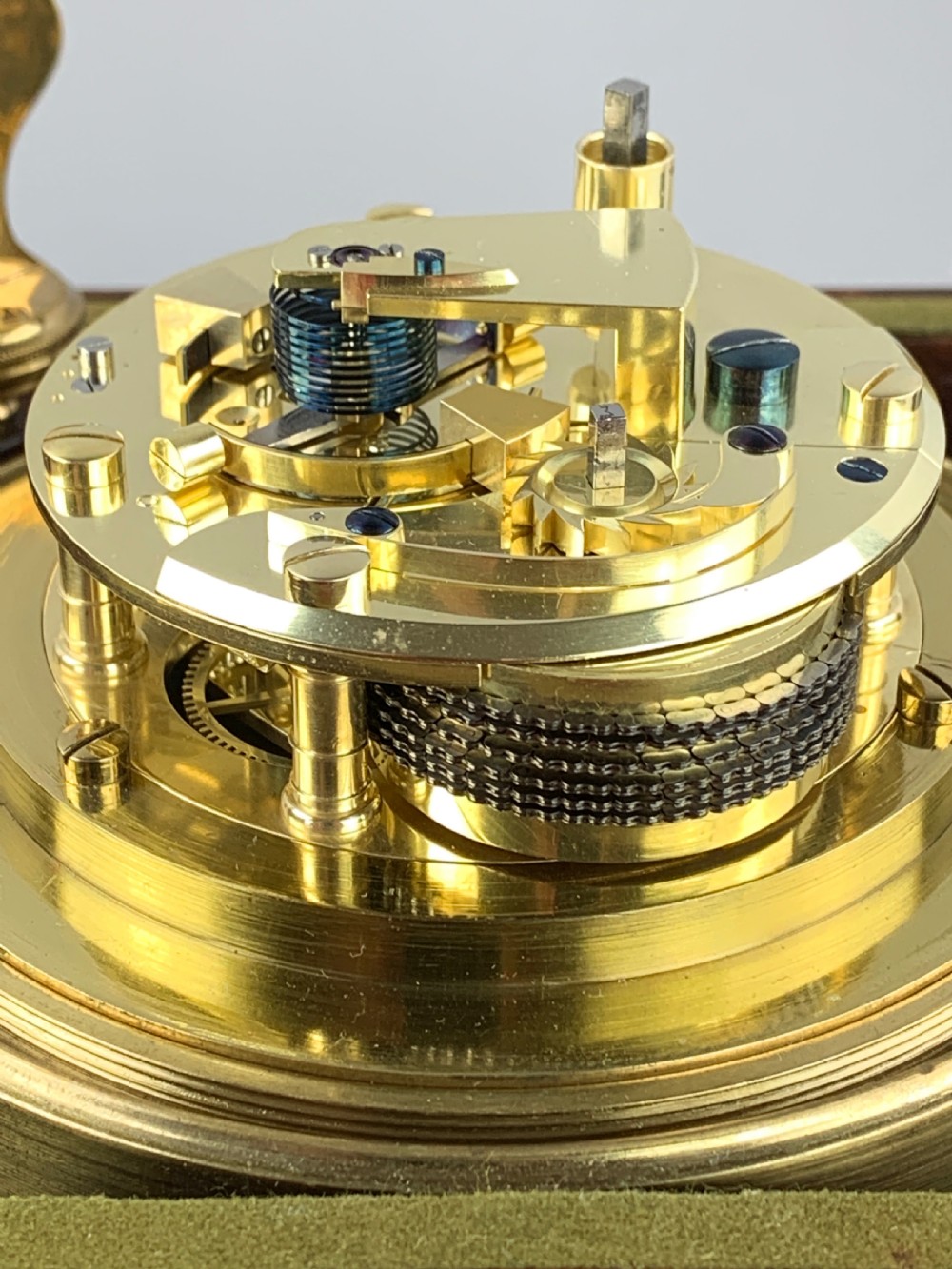 An antique 19th-century brass-bound wooden box opening to reveal a gimballed marine chronometer clock with a silvered dial and Roman numerals. View VI