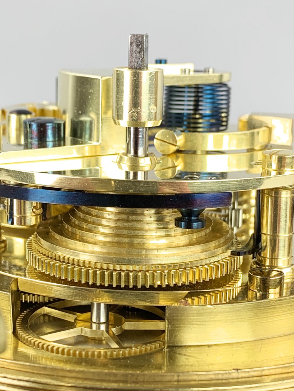 An antique 19th-century brass-bound wooden box opening to reveal a gimballed marine chronometer clock with a silvered dial and Roman numerals. View XI
