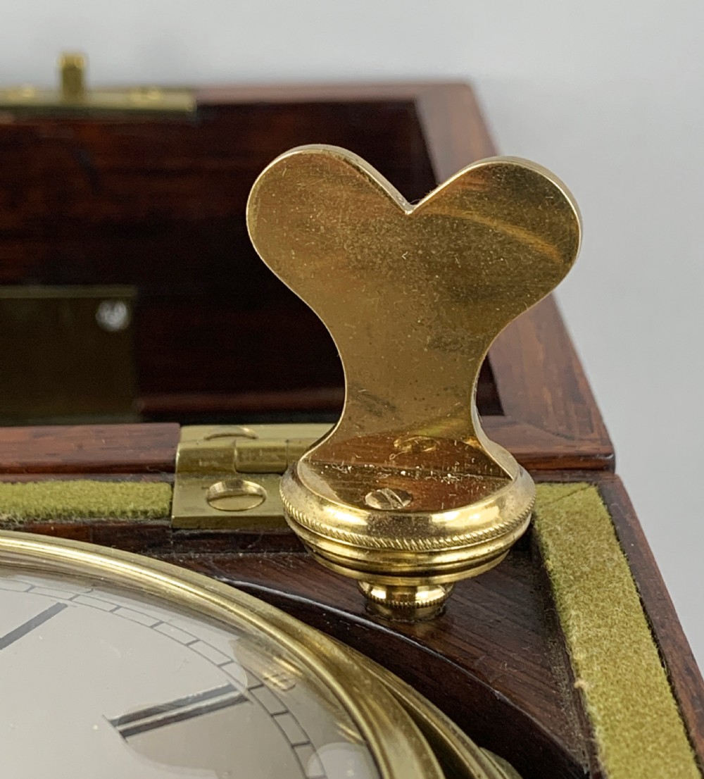An antique 19th-century brass-bound wooden box opening to reveal a gimballed marine chronometer clock with a silvered dial and Roman numerals. View XIII