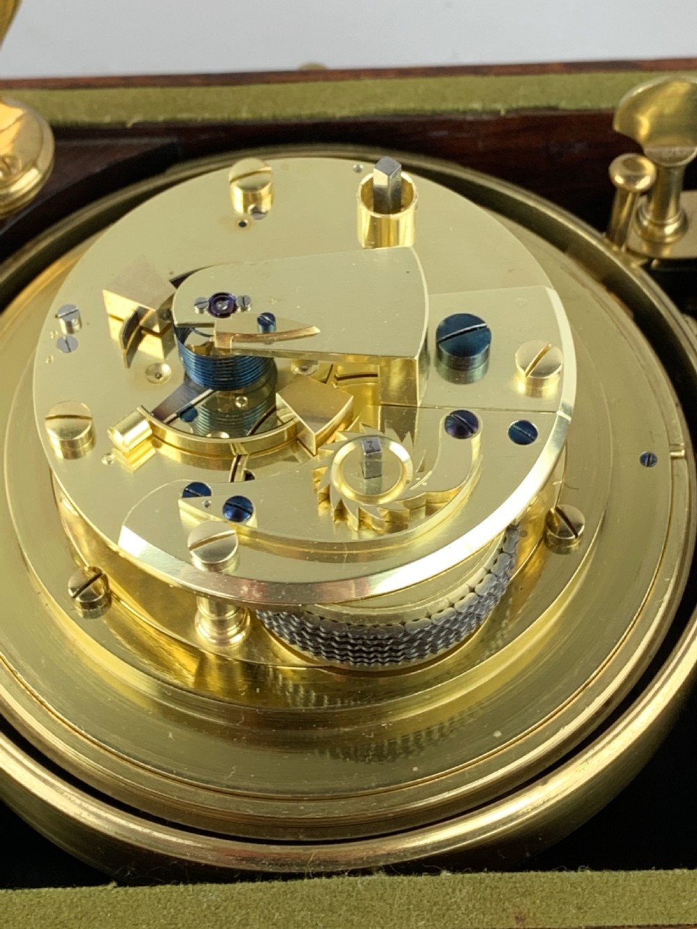 An antique 19th-century brass-bound wooden box opening to reveal a gimballed marine chronometer clock with a silvered dial and Roman numerals. View XVI