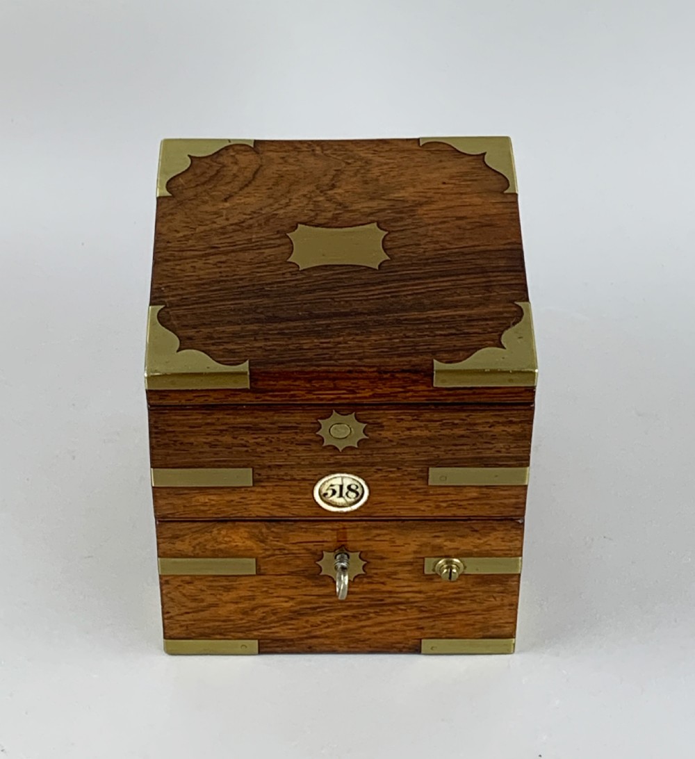 An antique 19th-century brass-bound wooden box opening to reveal a gimballed marine chronometer clock with a silvered dial and Roman numerals. View XIX