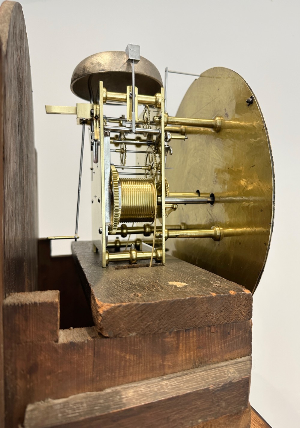 A tall Georgian flame mahogany longcase clock featuring an arched hood, brass finial, and a circular white dial with Roman numerals. View VI