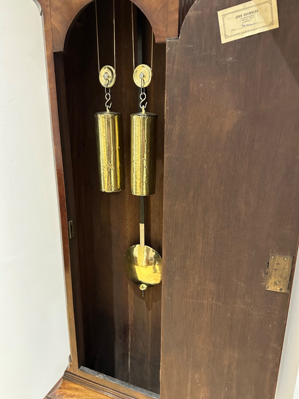 A tall Georgian flame mahogany longcase clock featuring an arched hood, brass finial, and a circular white dial with Roman numerals. View XIII