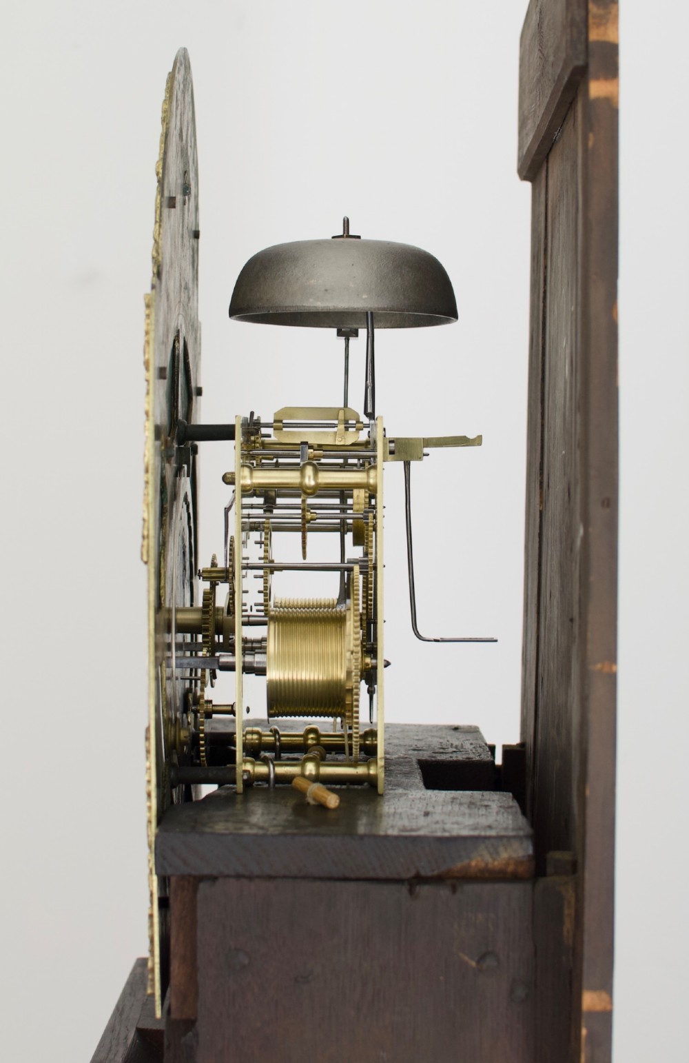 An 18th-century Georgian longcase clock featuring a dark wooden cabinet, an arched hood with a finial, and a brass dial with silvered chapter ring. View IV