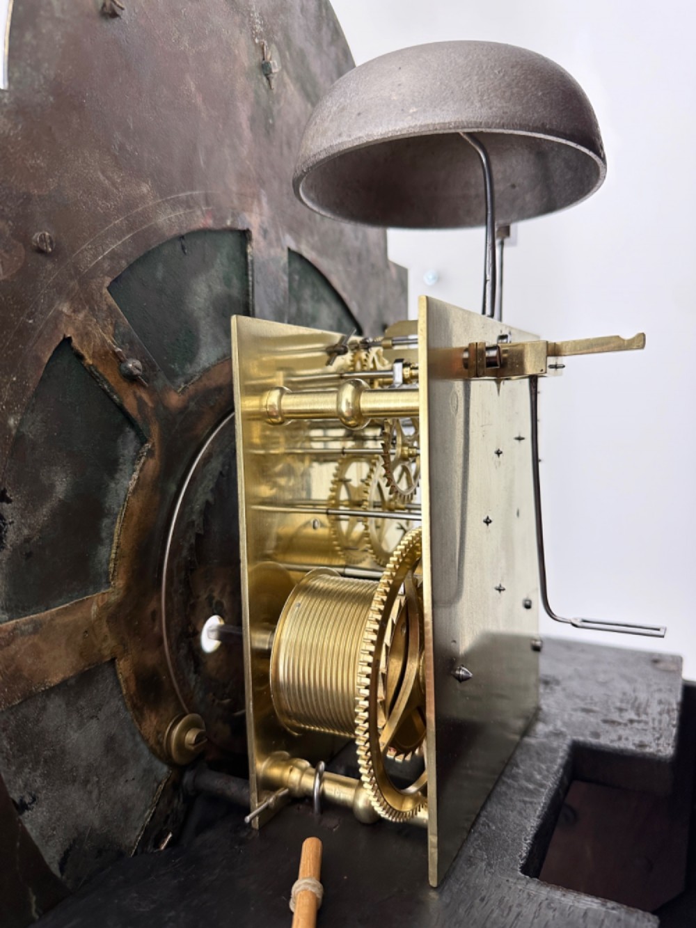 An 18th-century Georgian longcase clock featuring a dark wooden cabinet, an arched hood with a finial, and a brass dial with silvered chapter ring. View VI