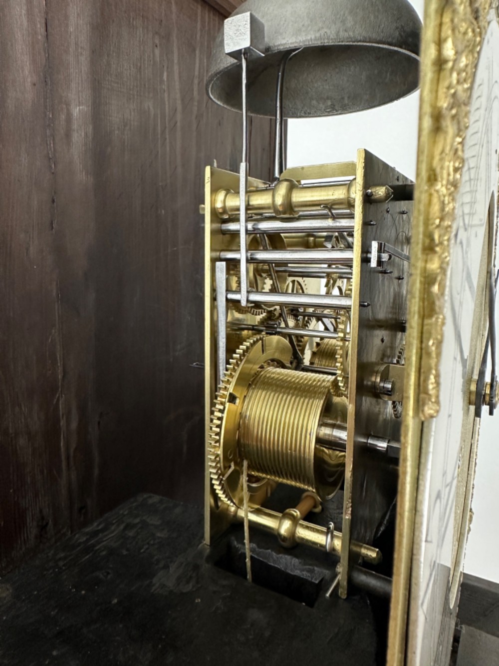 An 18th-century Georgian longcase clock featuring a dark wooden cabinet, an arched hood with a finial, and a brass dial with silvered chapter ring. View VIII