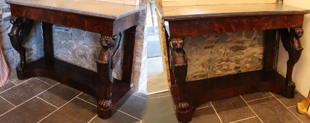 A French Empire mahogany console table featuring a grey marble top and carved winged griffin legs set on a plinth base. View II