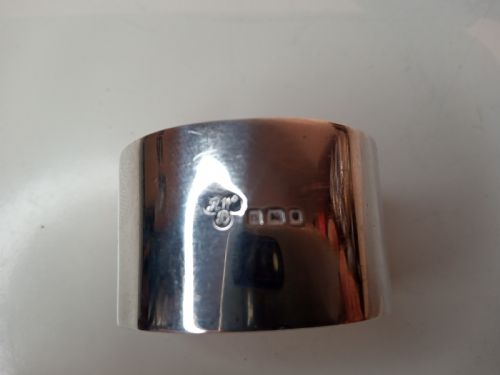 fig 1. A plain circular sterling silver napkin ring displaying stamped official hallmarks on the polished outer surface.