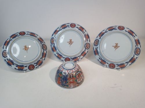 fig 1. A four-piece Japanese Imari porcelain set featuring three patterned display plates and a matching small bowl decorated with European ship motifs in red, blue, and gold.