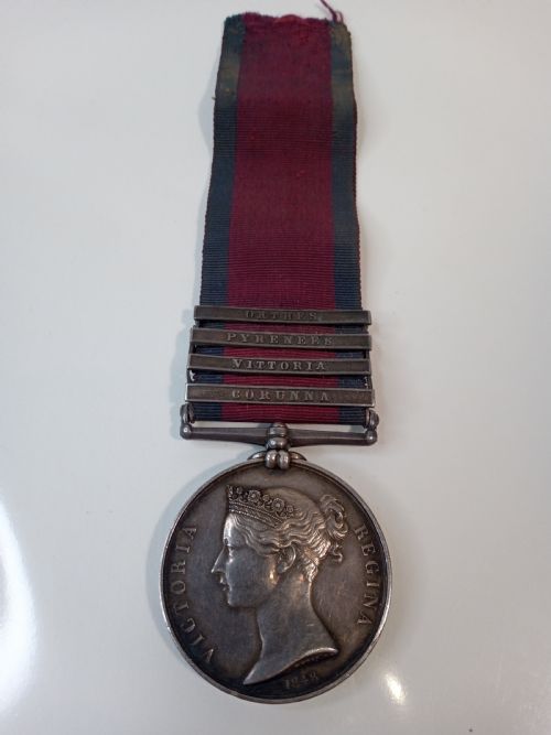 fig 1. A Victorian silver Military General Service Medal dated 1848 featuring four campaign clasps and Queen Victoria profile on a crimson and blue ribbon.