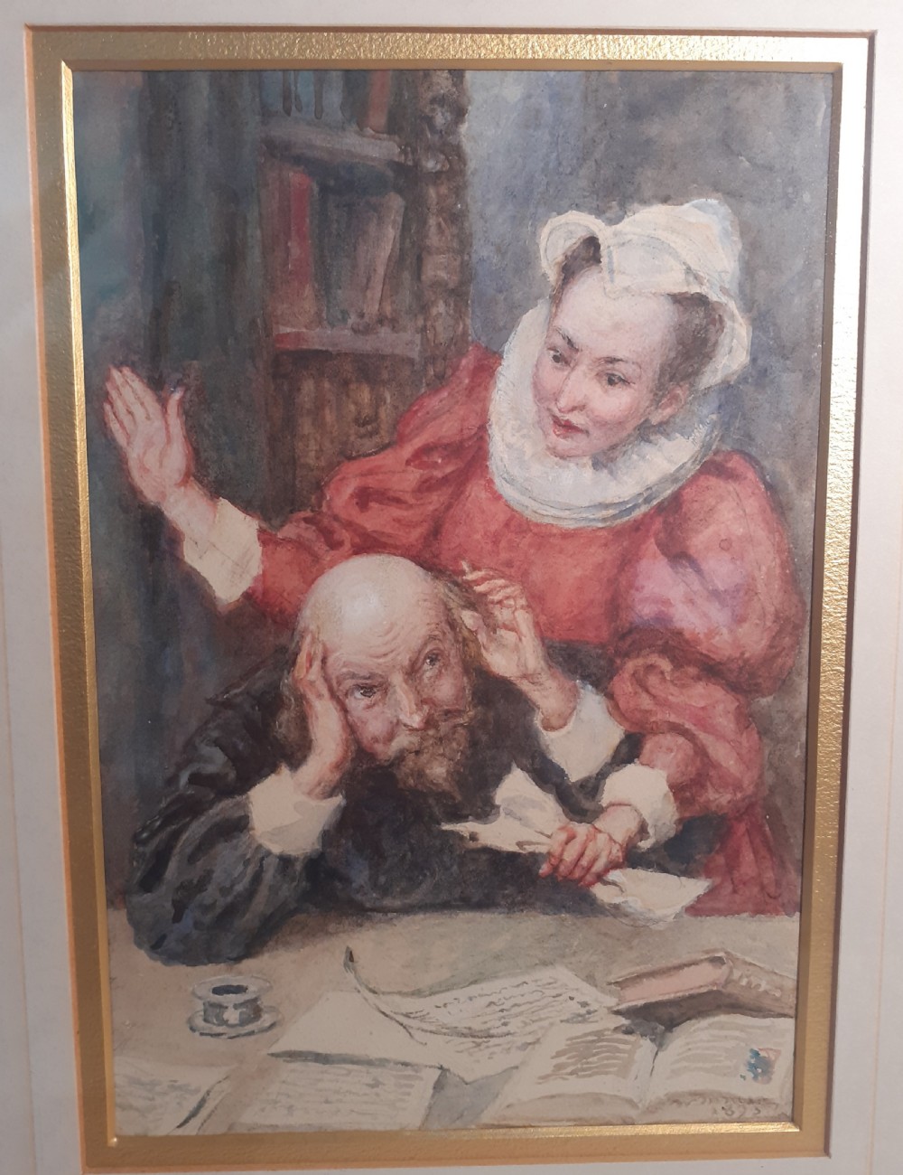 A framed late Victorian watercolour painting depicting William Shakespeare seated at a desk covered with manuscripts while Anne Hathaway stands behind him wearing a red Elizabethan dress. View II