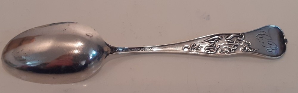An antique silver souvenir spoon featuring an embossed heraldic crest in the bowl dated 1891 and a decorative handle depicting an elm tree. View II