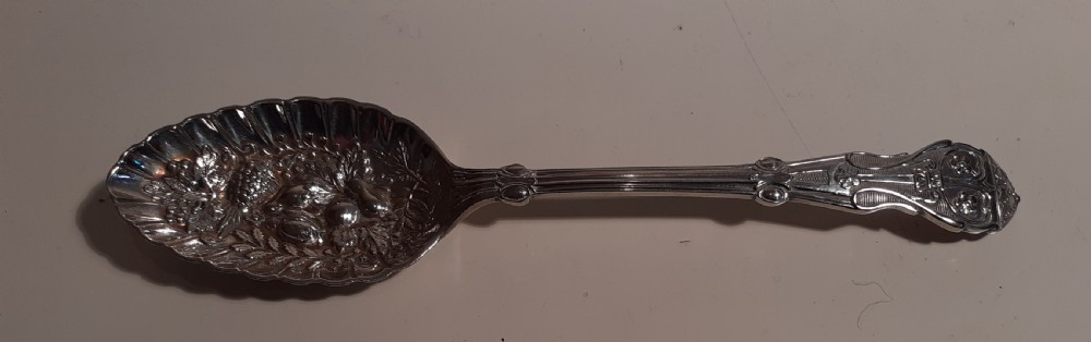 A Victorian silver plated berry spoon with an embossed fruit pattern bowl resting inside a black presentation case. View II