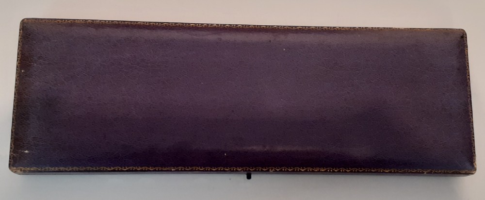 A boxed set of circular mother of pearl dress studs, pins, and metal fittings presented inside a purple satin-lined case. View II
