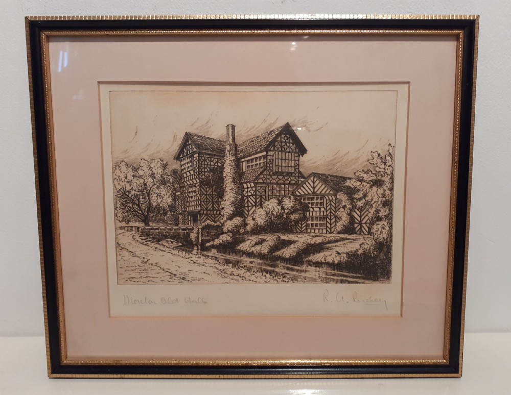 A framed monochrome architectural etching by R. A. Riseley depicting the half-timbered facade of Moreton Old Hall set within a dark frame with a beaded gilt inner border.