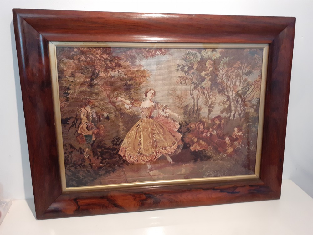 A nineteenth-century framed wool needlepoint artwork depicting a dancing figure in a landscape, presented in a polished rosewood frame.