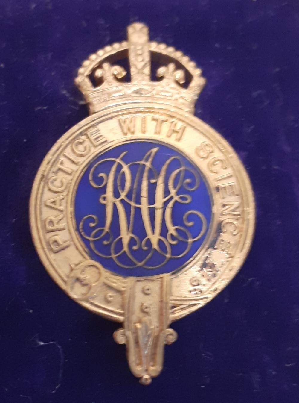 A 1930s gold-toned and blue enamel Royal Agricultural Society crowned badge displayed inside its original fitted burgundy presentation case. View II