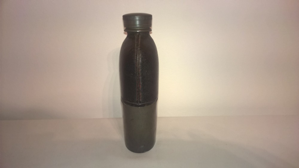 Late nineteenth century pocket hip flask featuring a black leather wrapped upper body and a pewter lower section with a screw top cap. View IV