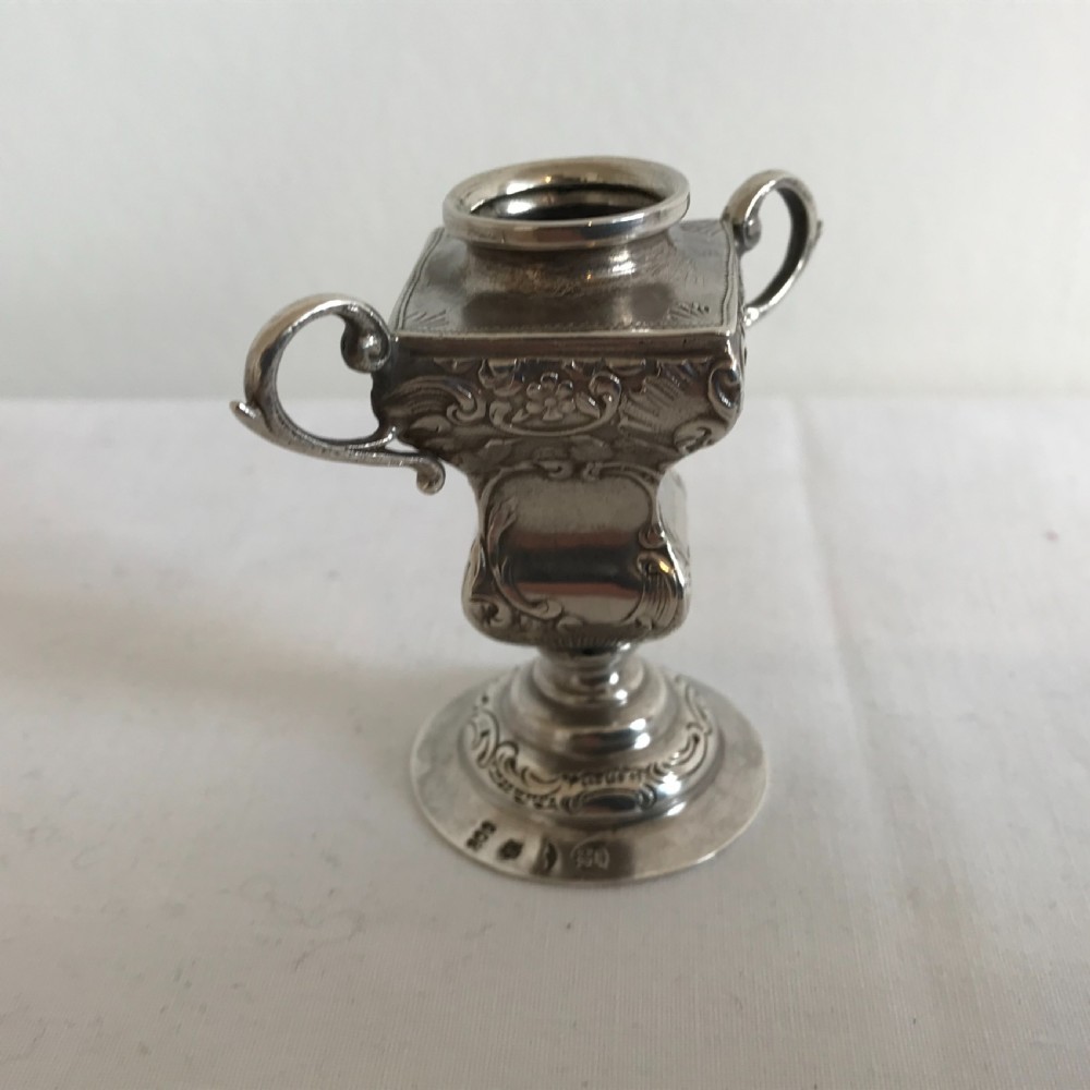 An ornate German silver miniature urn vase featuring scrolled handles, floral relief chasing, and a circular pedestal base. View II