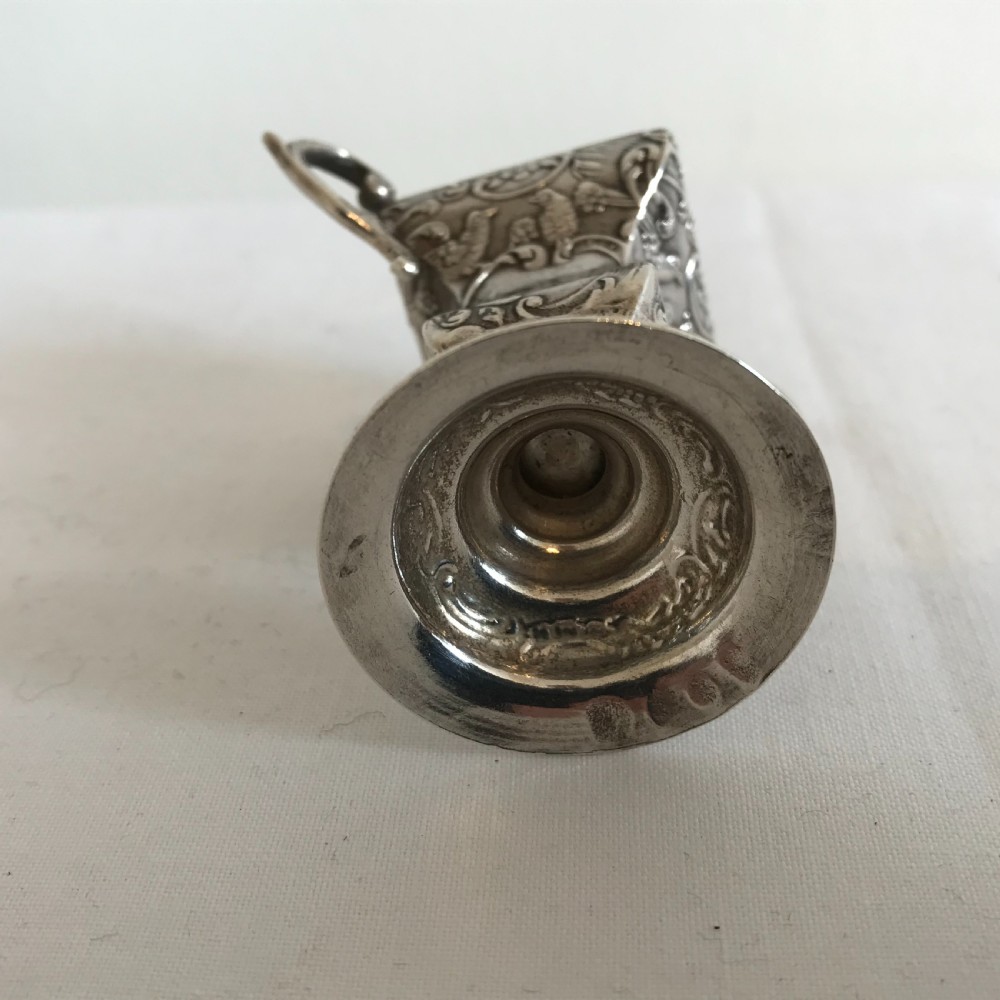 An ornate German silver miniature urn vase featuring scrolled handles, floral relief chasing, and a circular pedestal base. View IV