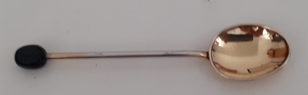 A set of six silver gilt coffee spoons with dark bean finials resting inside an open fitted presentation case lined with cream satin and dark velvet. View III