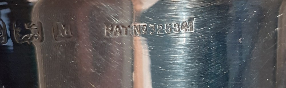 An Art Deco sterling silver sugar sifter featuring a stepped conical body and a pierced dome lid with a finial, displaying visible hallmarks on the upper body. View III