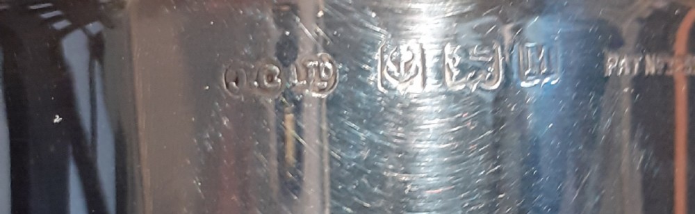An Art Deco sterling silver sugar sifter featuring a stepped conical body and a pierced dome lid with a finial, displaying visible hallmarks on the upper body. View IV