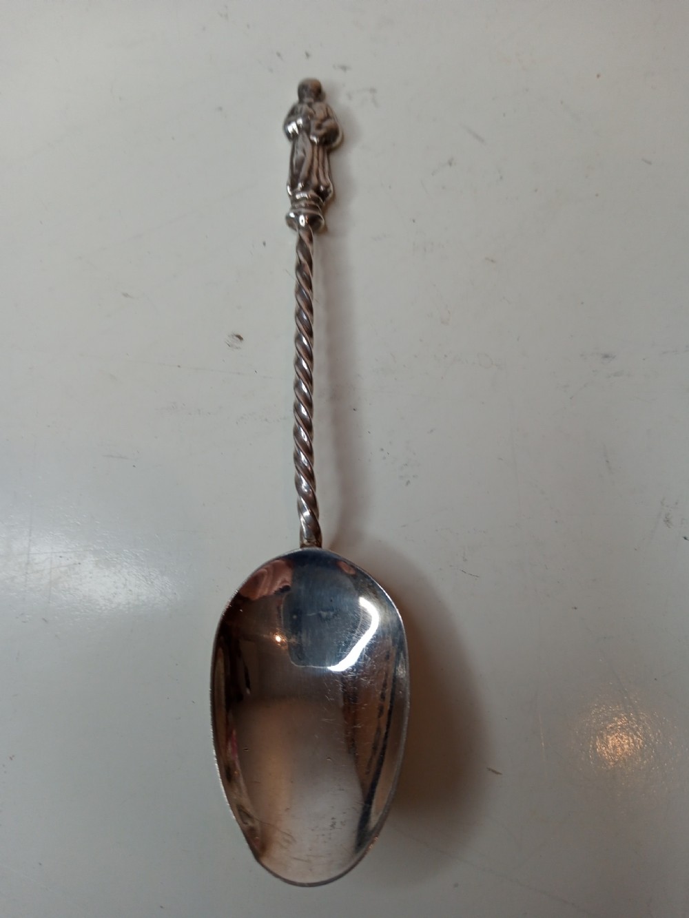 A late Victorian cased sterling silver set featuring six twisted-stem spoons with figural finials and matching sugar tongs housed in a blue velvet-lined box. View IV