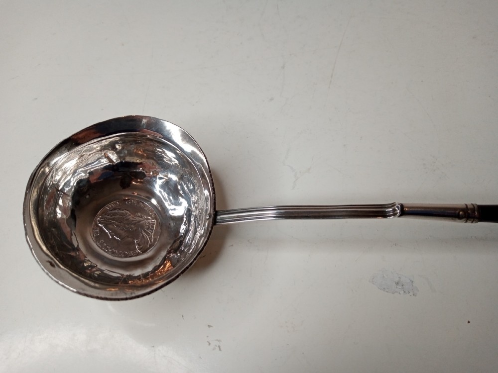 A Georgian silver toddy ladle bowl with an inset George III silver coin at the centre and a reeded handle joint. View IV