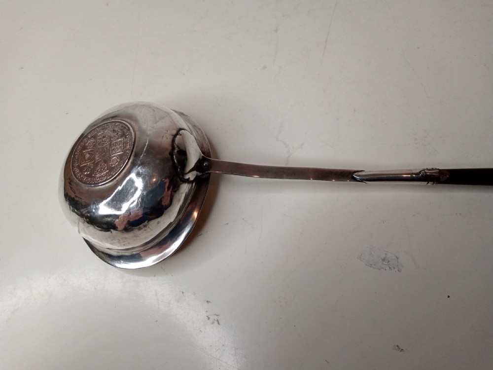 A Georgian silver toddy ladle bowl with an inset George III silver coin at the centre and a reeded handle joint. View V